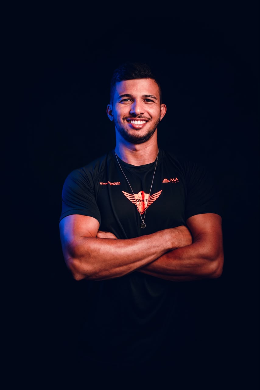 Retrato de Paulo Mateus, personal trainer em Uberaba, sorrindo de braços cruzados